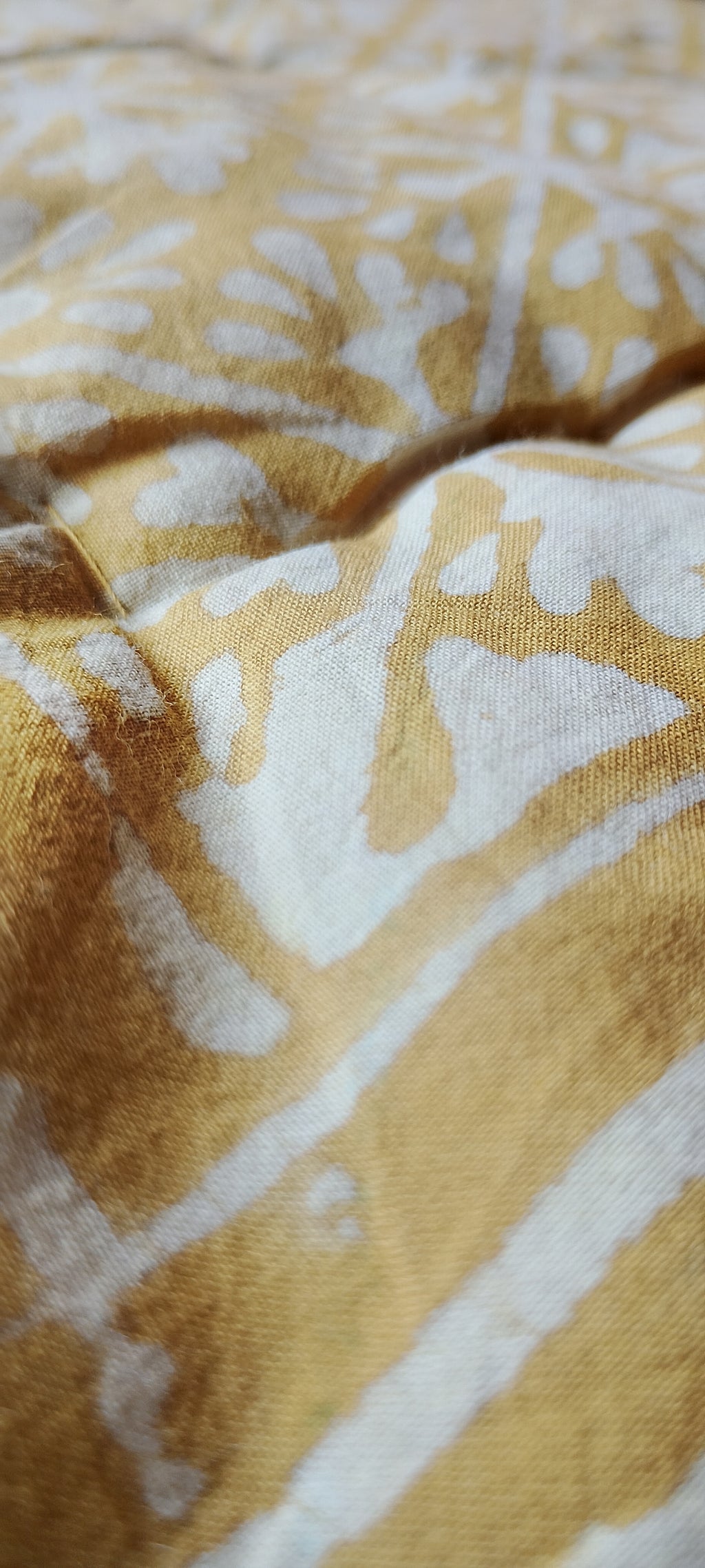 Close-up of a textured fabric with a yellow and white pattern