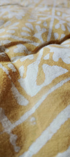 Close-up of a textured fabric with a yellow and white pattern